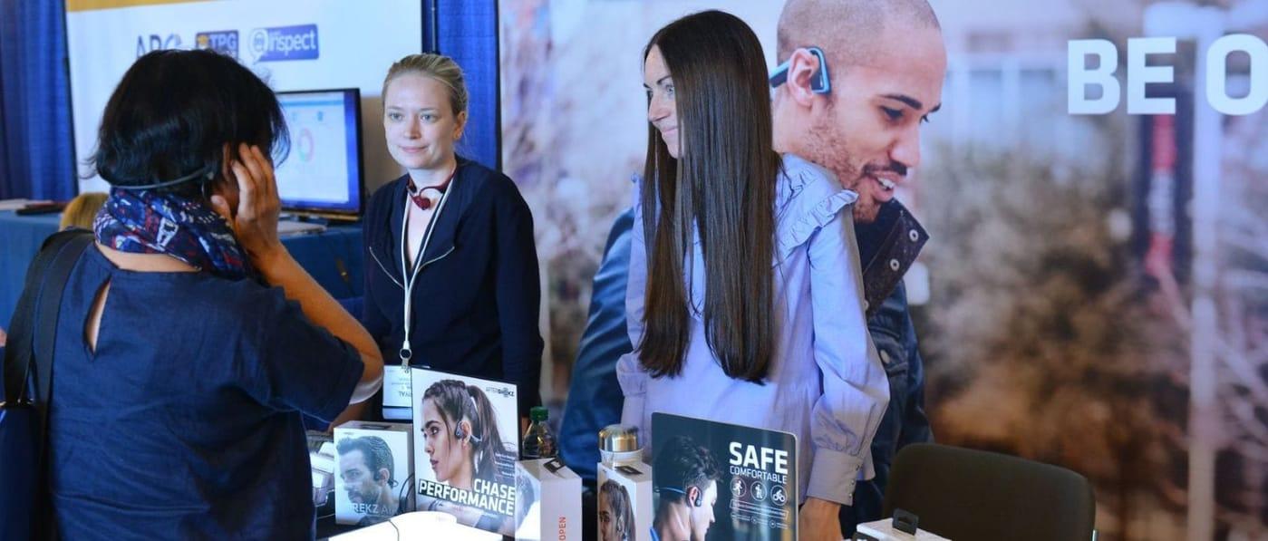 Image of an attendee talking to exhibitors at their booth.